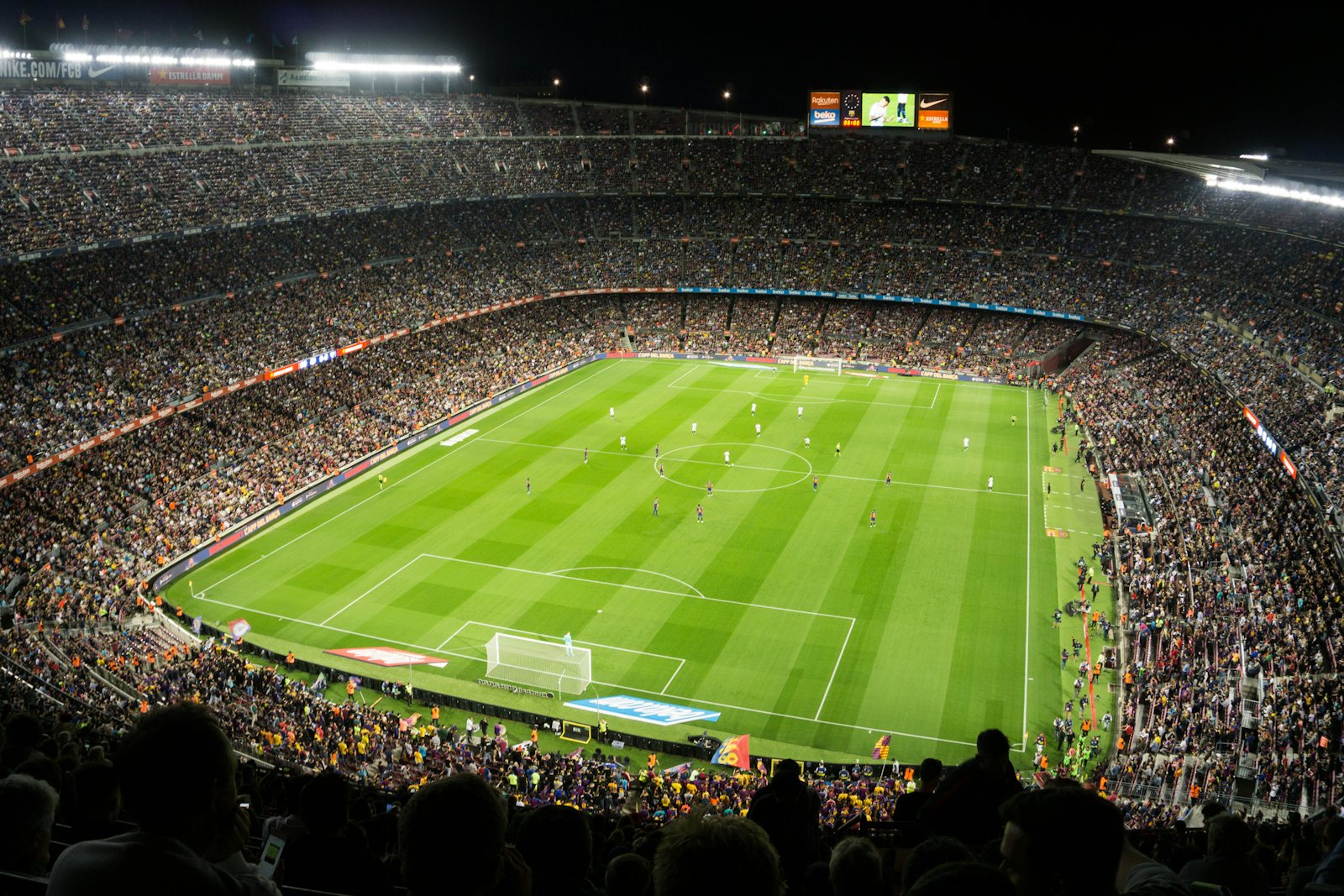 A packed football stadium under floodlights at night